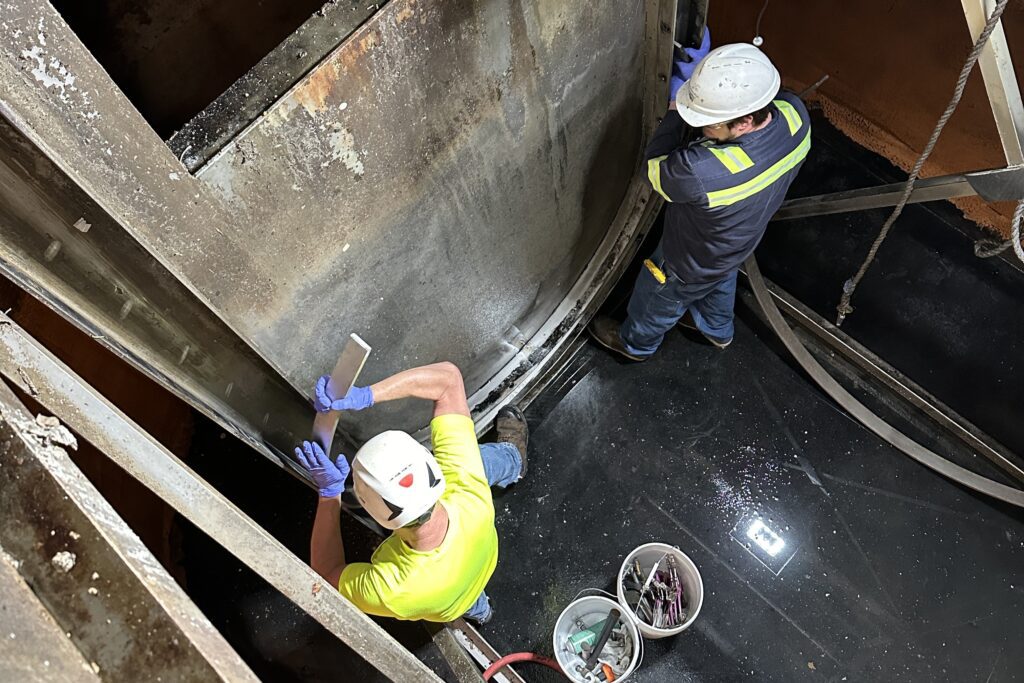 Mechanics Dan Westover and Matt Barrett install a new stainless steel strip inside the chamber. When the unit is running, the water level is about 5-6 feet high.