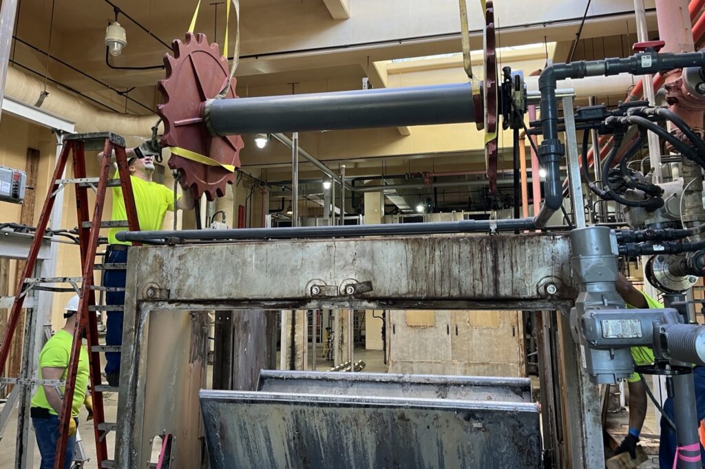 Shiny and new: the replacement sprocket and shaft are lowered into the unit as mechanics prepare it for installation in Screen 4.